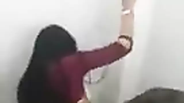 A brunette woman has sex with a Kyrgyz man in the restroom